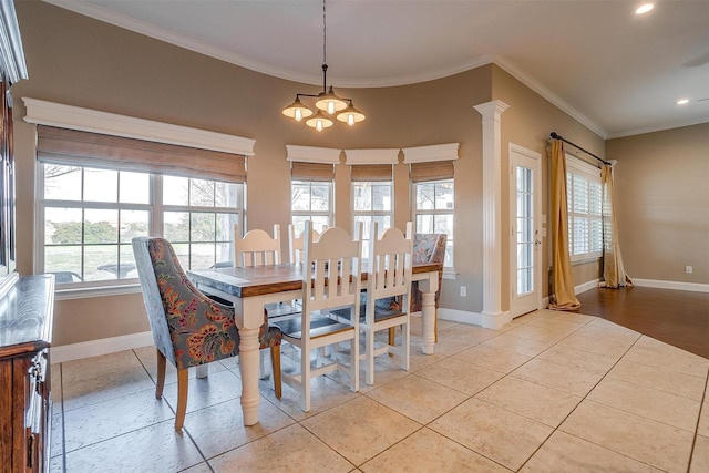 dining area featuring an inviting chandelier, crown molding, light tile patterned floors, and ornate columns