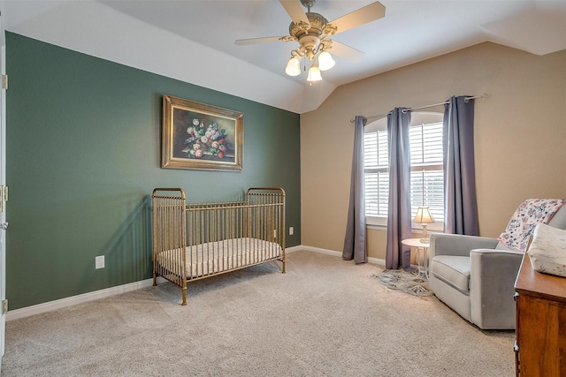 bedroom featuring ceiling fan, vaulted ceiling, light carpet, and a nursery area