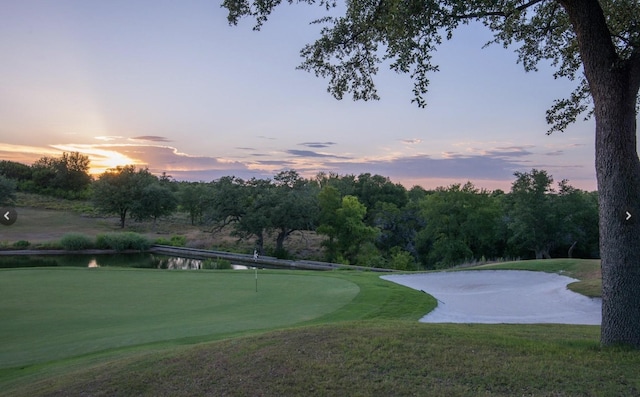 surrounding community featuring a water view and a lawn