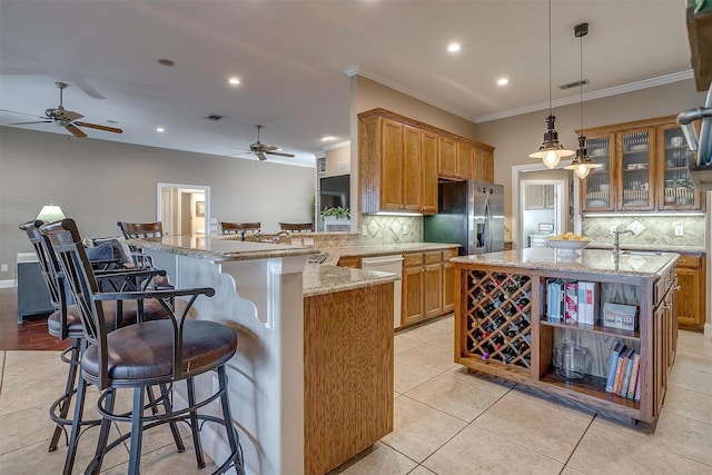 kitchen featuring appliances with stainless steel finishes, a kitchen bar, tasteful backsplash, and kitchen peninsula