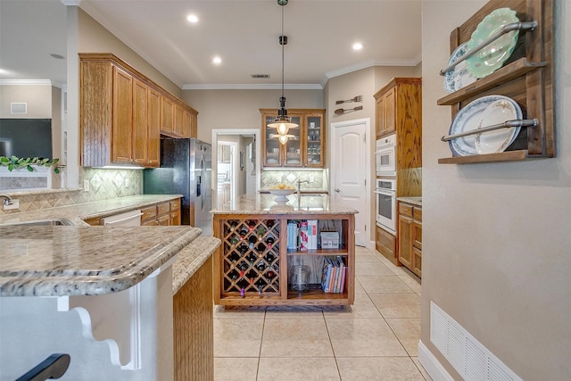 kitchen featuring sink, tasteful backsplash, kitchen peninsula, pendant lighting, and appliances with stainless steel finishes