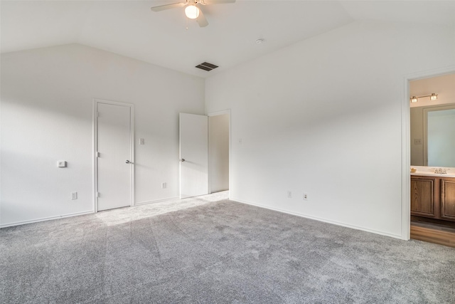 unfurnished bedroom featuring ceiling fan, light carpet, ensuite bathroom, and lofted ceiling