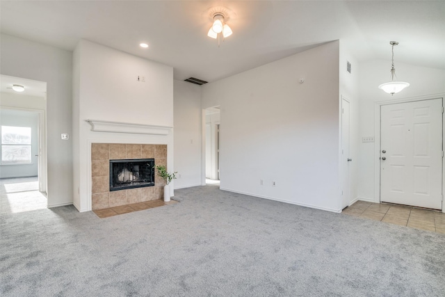 unfurnished living room featuring light carpet and a tile fireplace