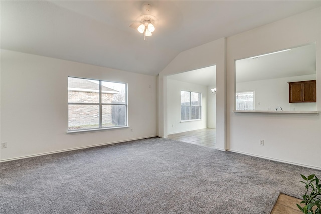 unfurnished living room with ceiling fan, light carpet, and vaulted ceiling