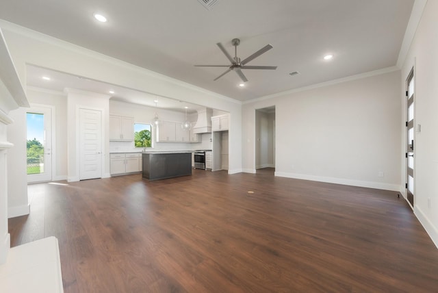 unfurnished living room with ceiling fan, plenty of natural light, crown molding, and dark hardwood / wood-style floors