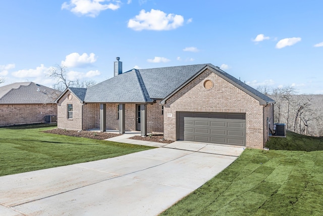 view of front of property featuring central AC, a garage, and a front lawn