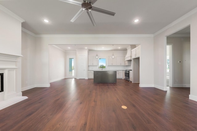 unfurnished living room featuring dark wood-type flooring, ceiling fan, and crown molding