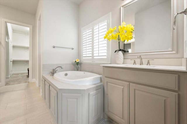 bathroom featuring tile patterned flooring, vanity, and a tub