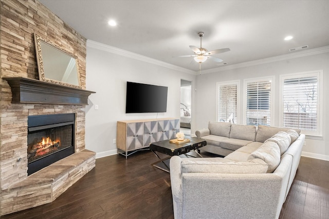 living room featuring ceiling fan, dark hardwood / wood-style floors, crown molding, and a fireplace