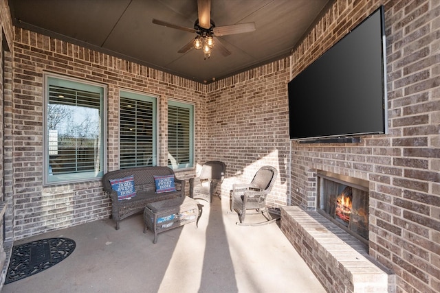 view of patio featuring an outdoor brick fireplace and ceiling fan