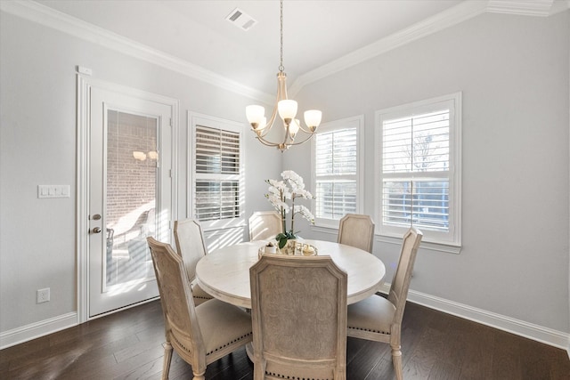 dining room featuring dark hardwood / wood-style flooring, ornamental molding, and a chandelier