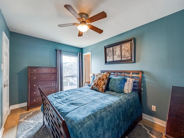 bedroom with a textured ceiling, ceiling fan, and wood-type flooring