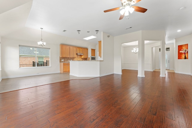 unfurnished living room with dark hardwood / wood-style flooring and ceiling fan with notable chandelier