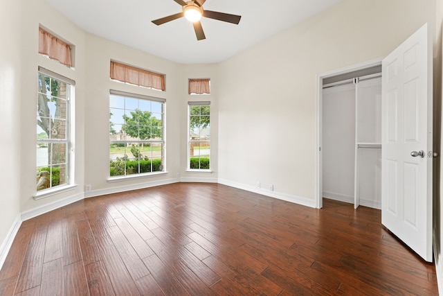 unfurnished bedroom with dark hardwood / wood-style flooring, a closet, and ceiling fan