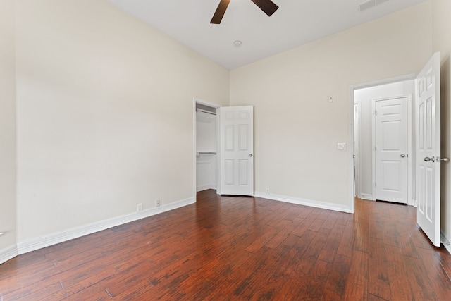 unfurnished bedroom with ceiling fan, dark hardwood / wood-style flooring, and a high ceiling