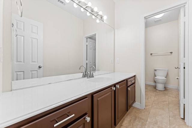 bathroom with tile patterned flooring, vanity, and toilet