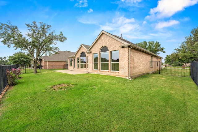 back of property with a patio area and a lawn