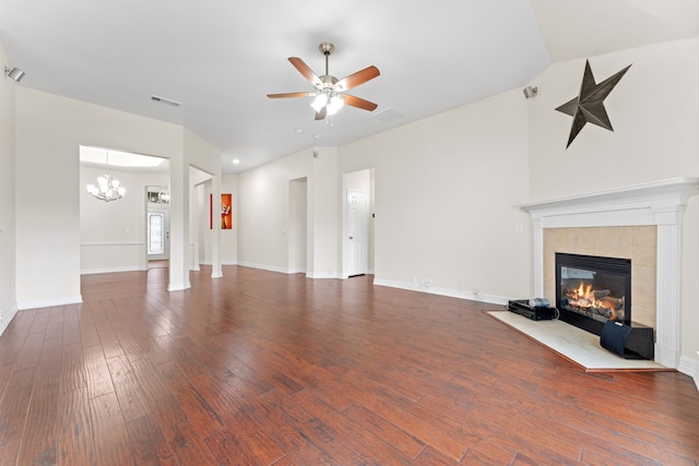 unfurnished living room featuring ceiling fan with notable chandelier, a fireplace, and dark wood-type flooring