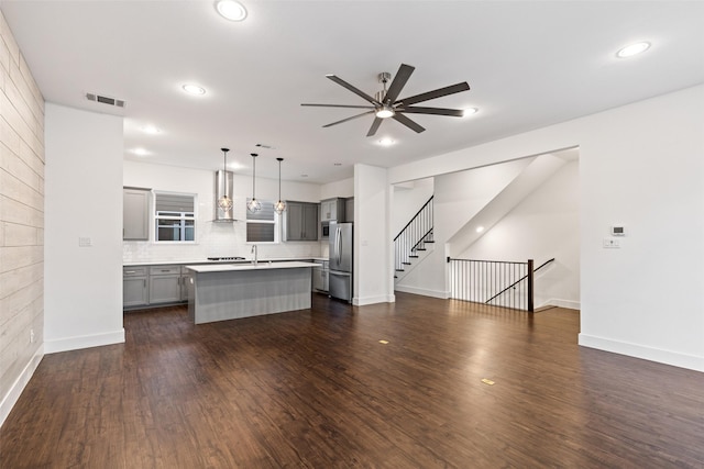 unfurnished living room featuring sink, dark wood-type flooring, and ceiling fan