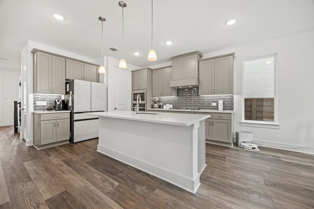 kitchen with gas cooktop, pendant lighting, white refrigerator, and gray cabinetry