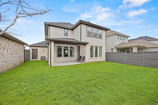 rear view of property with central air condition unit, a patio area, and a yard