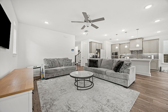 living room featuring ceiling fan and light hardwood / wood-style flooring