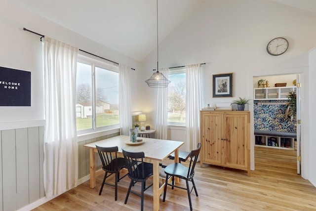 dining space featuring a healthy amount of sunlight, vaulted ceiling, and wood-type flooring