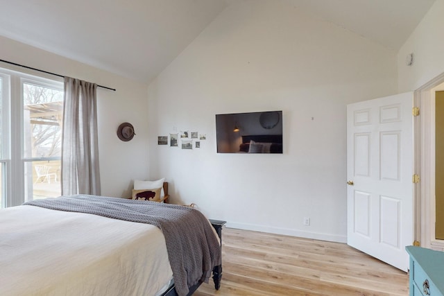 bedroom with lofted ceiling and light hardwood / wood-style floors