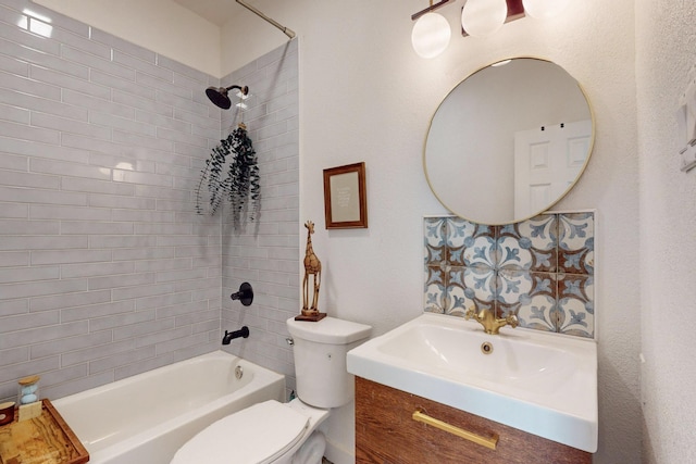 full bathroom with tiled shower / bath, vanity, and toilet