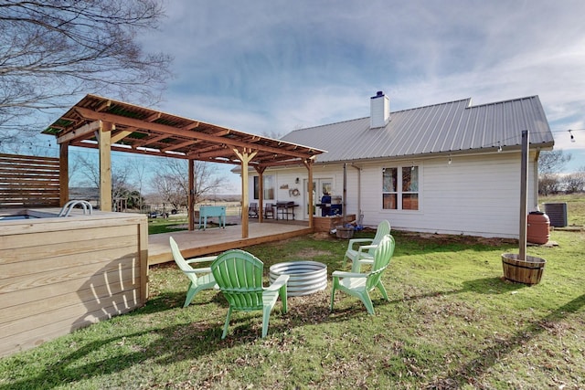 rear view of house with central air condition unit, a yard, and a wooden deck