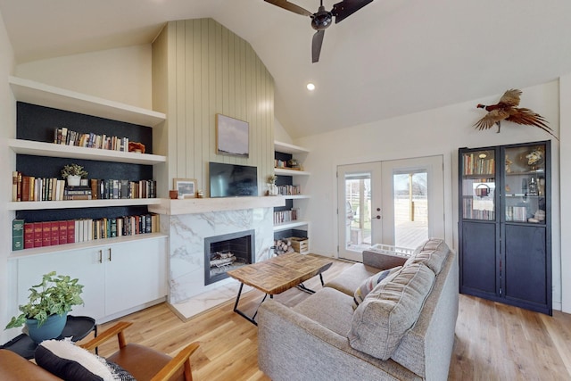 living room with vaulted ceiling, built in shelves, and french doors