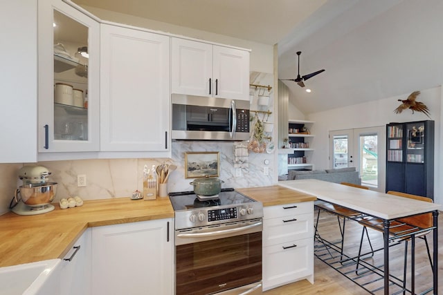 kitchen featuring appliances with stainless steel finishes, wood counters, and white cabinetry