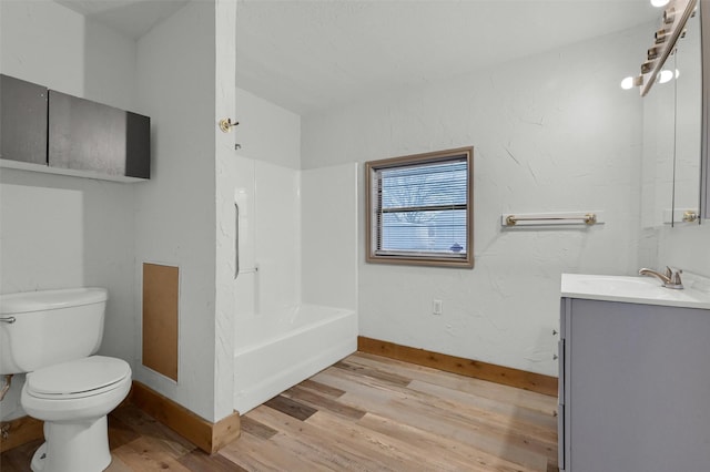 full bathroom with toilet, washtub / shower combination, vanity, and hardwood / wood-style floors