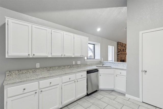 kitchen featuring sink, white cabinetry, dishwasher, light tile patterned flooring, and light stone countertops