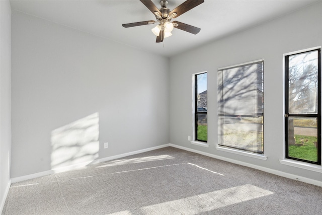 carpeted spare room with ceiling fan and plenty of natural light