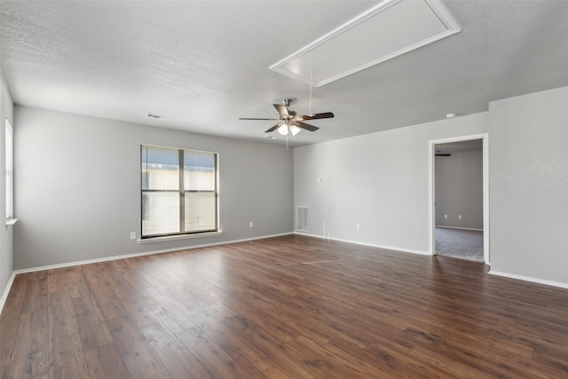 spare room with a textured ceiling, ceiling fan, and dark hardwood / wood-style floors