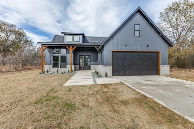 modern farmhouse featuring a front yard and a garage