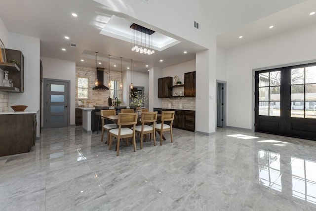 dining room with a notable chandelier, french doors, and a tray ceiling