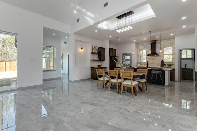 dining space featuring sink, a wealth of natural light, and a chandelier