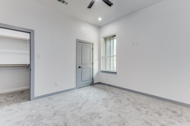 unfurnished bedroom featuring light carpet, a closet, and ceiling fan