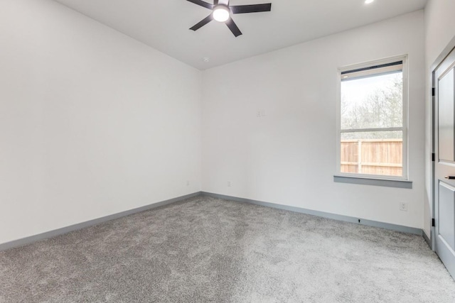 carpeted spare room featuring ceiling fan