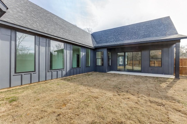 back of house with a lawn and a patio