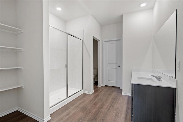 bathroom with toilet, an enclosed shower, wood-type flooring, and vanity