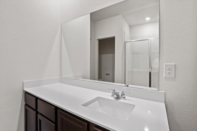 bathroom featuring an enclosed shower and vanity