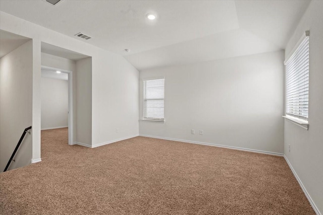 spare room featuring vaulted ceiling and carpet