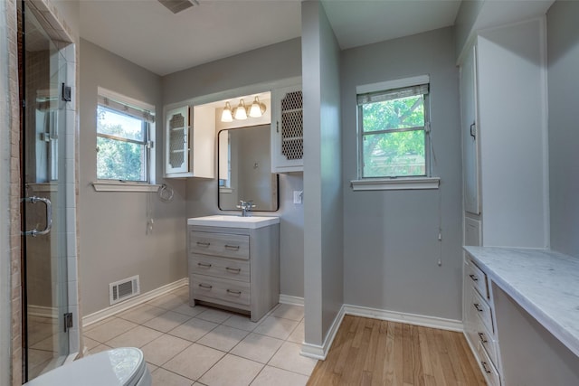 bathroom with a shower with door, vanity, and toilet