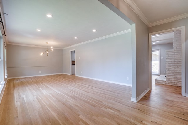 unfurnished room with a notable chandelier, light wood-type flooring, and crown molding