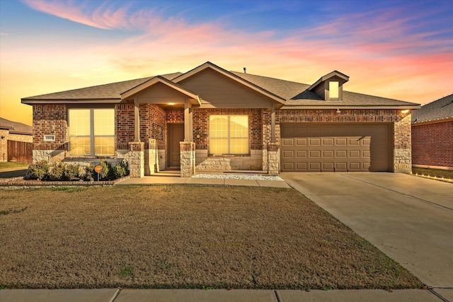 view of front of home with a garage and a yard