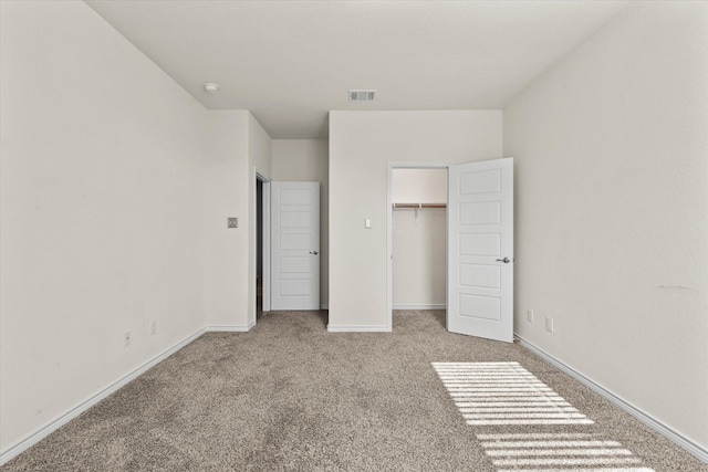 unfurnished bedroom with light carpet and a closet