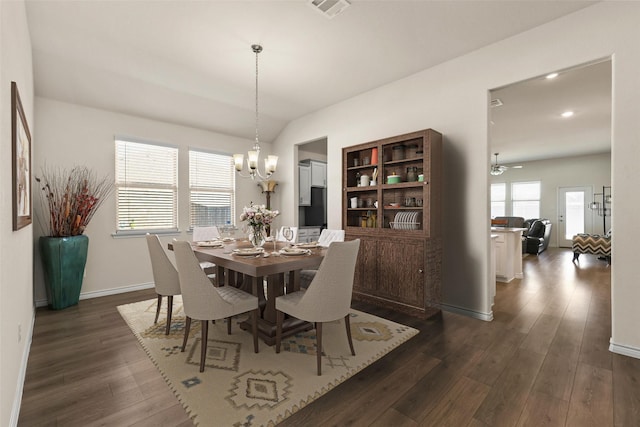 dining space with plenty of natural light, dark hardwood / wood-style floors, a notable chandelier, and vaulted ceiling